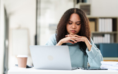 African American university student looking worried or stressed while working on her MBA project on...