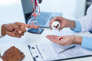 Doctor hands holding sectional model of prostate gland while male patient observes, suggesting...