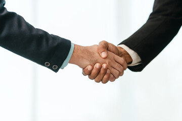 close-up of two men in business suits shaking hands, likely concluding a discussion or agreement, possibly in fields such as stock market investment, law, or real estate.