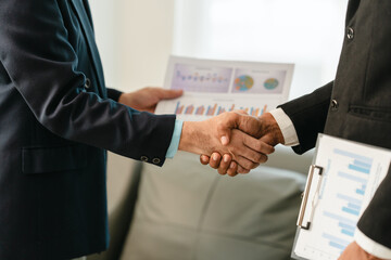 close-up of two men in business suits shaking hands, likely concluding a discussion or agreement, possibly in fields such as stock market investment, law, or real estate.