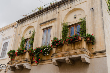 Fototapeta na wymiar Facade of a beautiful balcony with fresh flowers. Italy. Turin.