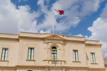 Fototapeta na wymiar Maltese flag on a building against the sky.