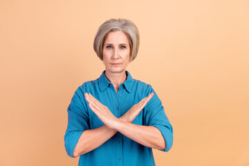 Portrait of strict serious senior person with white gray hairdo holding arms crossed show stop...