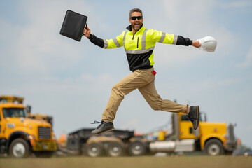 Construction man excited jump with helmet. Builder in helmet outdoor portrait. Worker in hardhat. Construction engineer worker in builder uniform on construction. Excited foreman jump.