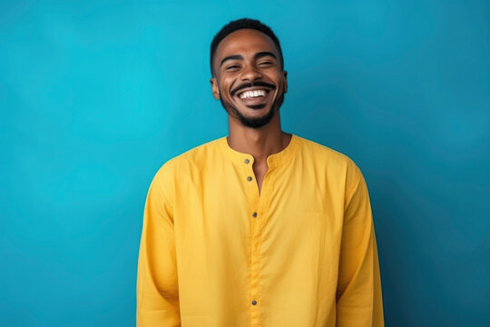 happy Moroccan man with typical moroccan tunic standing against blue wall. High quality photo