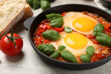 Delicious Shakshuka served on light grey table, closeup