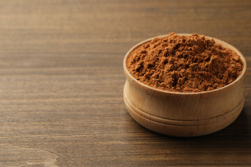 Obraz na płótnie Canvas Aromatic cinnamon powder on wooden table, closeup. Space for text