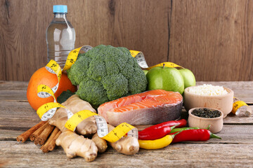 Metabolism. Different food products and measuring tape on wooden table