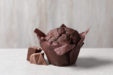 Tasty chocolate muffin on grey table, closeup