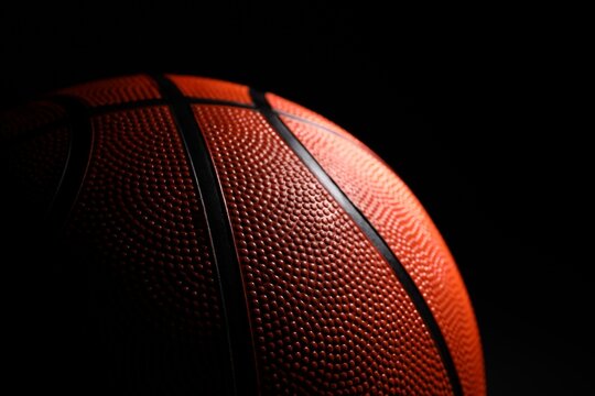One basketball ball on black background, closeup