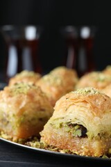 Delicious fresh baklava with chopped nuts on table, closeup. Eastern sweets