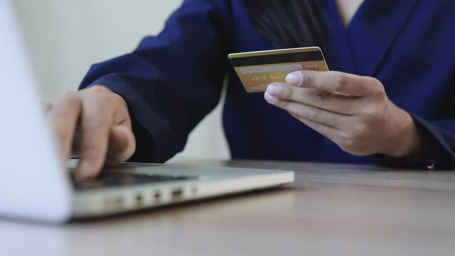 Woman hold credit card and typing information on laptop. payment online concept