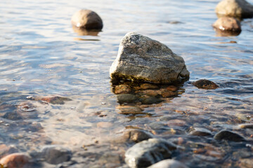 Seashore with round stones and calm water