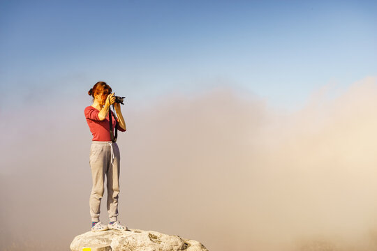 Woman with camera in mountains take travel photo