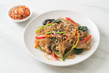 japchae or stir-fried Korean vermicelli noodles with vegetables and pork topped with white sesame