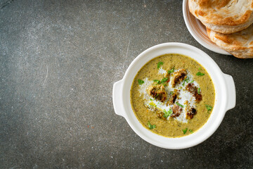 Afghani chicken in green masala curry or Hariyali tikka chicken hara masala with roti or naan bread