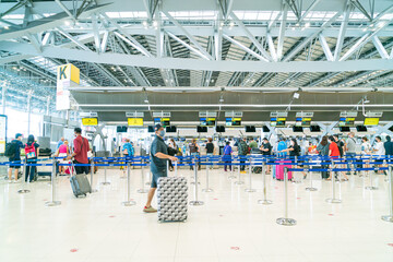Obraz premium Bangkok, Thailand - May 23, 2022 : Bangkok Suvarnabhumi airport passengers inside the departure terminal, people in medical masks from coronavirus.