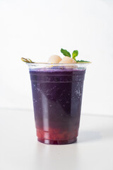 strawberry syrup and butterfly pea juice with fresh lychee on top