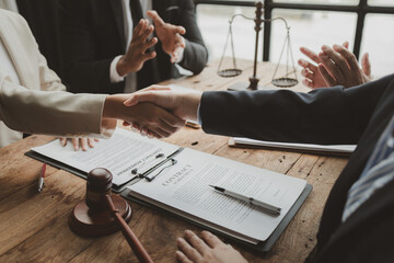 Crop shot of person with pen signing contract at desk in the office, Business people negotiating a contract, discussing contract while working together in sunny modern office, shaking hands.