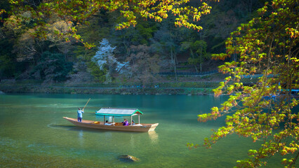 Kyoto, Japan - March 29 2023: Unidentified people ride a boat that sails in Katsura river  in Arashiyama district - obrazy, fototapety, plakaty