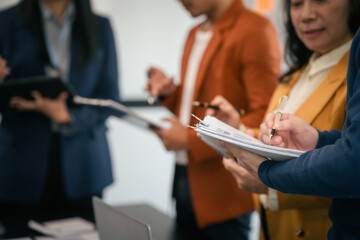 Asian business professionals team actively engaged in collaborative meeting in boardroom, sharing opinions and working together with visible happiness.