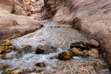 Fototapeta premium A small rapids along a shallow stream at the start of the Wadi Numeirah hiking trail in Jordan