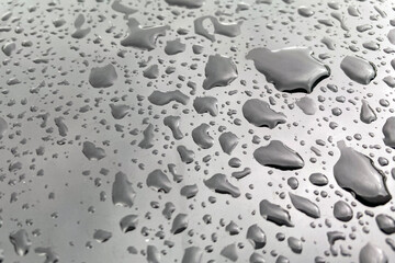 Large drops of water on a black glossy surface