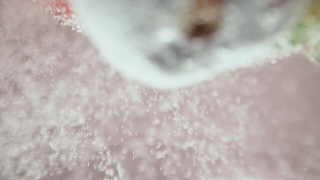 A macro video showing blueberries and strawberries splashing in seltzer water