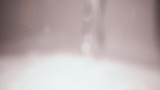 A macro video showing seltzer water pouring into a glass.