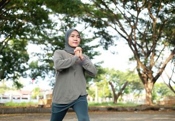 Fototapeta premium portrait of healthy asian woman with hijab doing exercise at the park in the morning