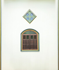 exterior with wooden casement window and colorful glasses on white wall