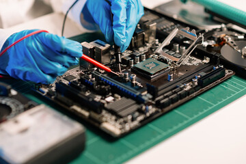 The technician is putting the CPU on the socket of the computer motherboard. electronic engineering...