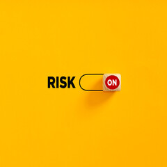 Risk on slider button on yellow background. Risk taking or risk management in business.