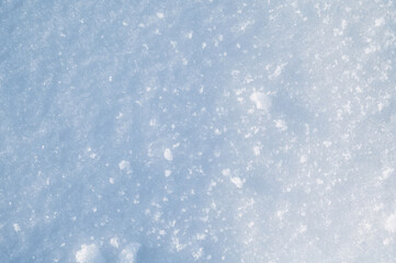 background with a texture of white blue snow on a snowdrift on a cold sunny winter day