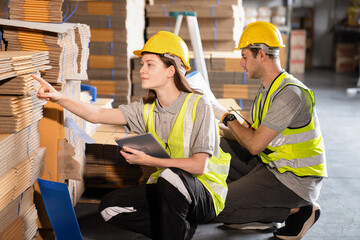 Warehouse worker and managers check stock and inventory by using digital tablet computer in the...