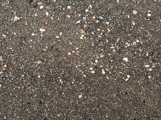 Black micro stones and sea shells sand beach as a background