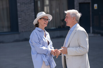 Stylish elderly laughing couple on a walk. Romantic relationships of mature people. 