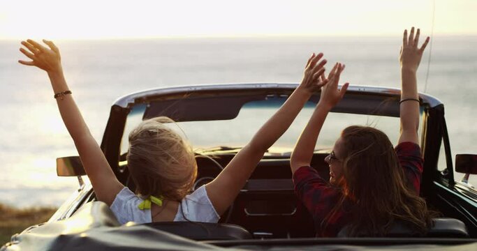 Women on road trip with car, beach and dancing with freedom, nature and view of sunset. Happy travel friends in convertible, music on adventure and journey at ocean with excited celebration from back