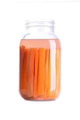 Carrot sticks, homemade fermented carrots, in a glass jar. Carrots cut into sticks and fermented by lactic acid bacteria. Unpasteurized and uncooked they provide probiotics and improve digestion.