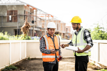 Asian people, two man, holding blueprints Structural engineers examine structural plans for office...