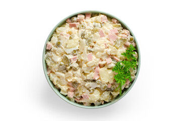 Olivier salad in a plate on a white background. Olivier salad with parsley. Top view.