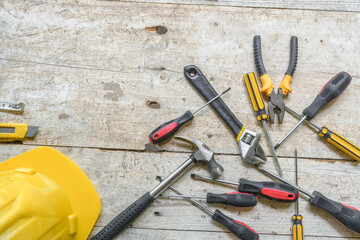 assortment of well-used hand tools spread out on a worn wooden surface, indicative of a workspace...