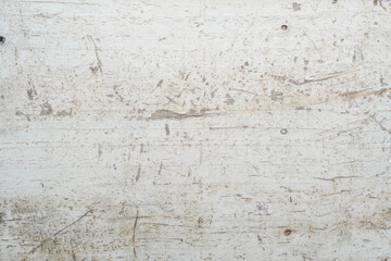 weathered and worn wooden surface with visible cracks, holes, and scratches, typical of an old workbench or floor.