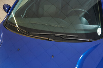 Obraz premium blue car windshield, steering wheel, front panel, wipers, washer nozzles mounted on the hood