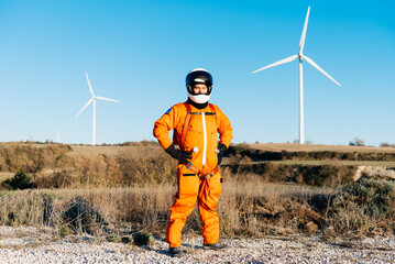 Mature man in a spacesuit standing against wind turbines © GALDRIC
