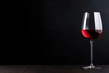 Fotobehang red wine on a glass against black background, Space for text © Muh
