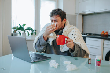 Homebound Flu Relief Young Man in Duvet Shivers and Wipes Nose on Kitchen Chair
