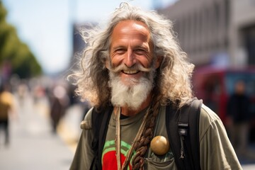 Portrait of a senior man with long grey hair and beard in the city.