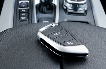 Closeup inside vehicle of wireless key ignition. Start engine key. Car key remote in black...