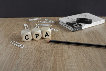 CPA certified public accountant symbol. On the table are a pencil, paper clips, a notebook and...